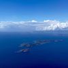 Experimente la impresionante vista de una exuberante isla verde rodeada por el océano azul profundo bajo un cielo despejado con nubes dispersas, como si volara en una "Sobrevuela en avión las Islas Cíes (Vigo)", capturando el encanto encantador de las Islas Cíes cerca de Vigo. - ForTwo - Planes para parejas