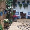 Explora el acogedor patio adornado con plantas en macetas, sillas azules y un diseño de piso de mosaico de guijarros que recuerda a los patios cordobeses en nuestro "Tour guiado por los patios cordobeses". - ForTwo - Planes para parejas