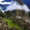 Una vista aérea de Machu Picchu muestra antiguas ruinas de piedra y terrazas verdes que se combinan armoniosamente entre picos brumosos: una imagen clásica del Viaje a Perú de 6 días. - ForTwo - Planes para parejas
