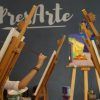 En una vibrante clase de arte, la gente pinta en caballetes debajo de la frase "Taller creativo de pintura de cuadros (Madrid)" en la pared, encarnando el espíritu de un taller creativo en Madrid. - ForTwo - Planes para parejas
