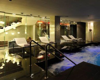 Experimente una relajación de lujo con el Circuito Spa + Masaje para dos en el Grums Hotel Spa de Barcelona. Disfrute de tumbonas, una piscina de burbujas, iluminación moderna bajo la escalera y tratamientos de spa rejuvenecedores. - ForTwo - Planes para parejas
