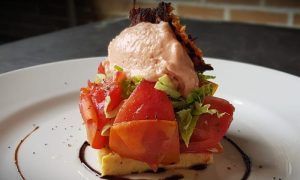 Disfrute de un plato gourmet del Menú para dos La Factoría de Parrilla García (Tenerife) con tomates frescos, lechuga sobre pan, cubierto con mousse rosa y glaseado balsámico. - ForTwo - Planes para parejas