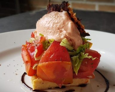 Disfrute de un plato gourmet del Menú para dos La Factoría de Parrilla García (Tenerife) con tomates frescos, lechuga sobre pan, cubierto con mousse rosa y glaseado balsámico. - ForTwo - Planes para parejas