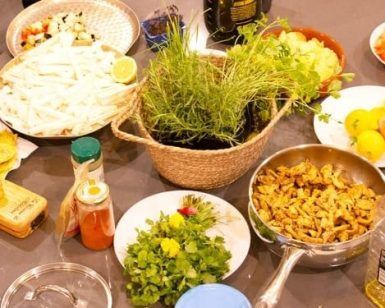 Una acogedora cocina en Sants exhibe una colorida variedad de hierbas, verduras cortadas en cubitos, pollo a la parrilla y salsas variadas con Taller de cocina en Sants con Taller 24, una muestra del encanto culinario de Barcelona. - ForTwo - Planes para parejas