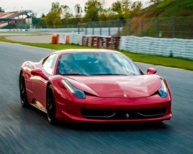 La experiencia "Conduce un Ferrari en Sevilla" ofrece la emoción de conducir un elegante Ferrari en un circuito de carreras, rodeado de exuberante vegetación y barreras para neumáticos. - ForTwo - Planes para parejas