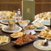 La mesa festiva de Sabores de India presenta la Oferta degustación Sabores de India: restaurante Bangalore (Madrid), completa con platos indios, botellas de cerveza y una estatua decorativa, que lleva el sabor de Bangalore al corazón de Madrid. - ForTwo - Planes para parejas