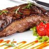 Disfrute de un delicioso filete a la parrilla adornado con romero, tomates cherry y lechuga rociado con salsa en el Restaurante La Oficina en Granada, parte del Menú mediterráneo para dos. - ForTwo - Planes para parejas
