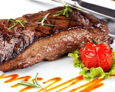 Disfrute de un delicioso filete a la parrilla adornado con romero, tomates cherry y lechuga rociado con salsa en el Restaurante La Oficina en Granada, parte del Menú mediterráneo para dos. - ForTwo - Planes para parejas