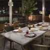 Restaurante Radio ME, situado en la azotea del Hotel Meliá Madrid, ofrece un elegante comedor al aire libre con una mesa para cuatro con asientos con cojines verdes e iluminación ambiental que crea una atmósfera nocturna mágica. - ForTwo - Planes para parejas