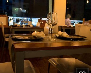 Una mesa para dos en la Degustación en Restaurante Ruta del Azafrán, adornada con copas de vino y servilletas, ofrece una vista mágica de la Alhambra. - ForTwo - Planes para parejas