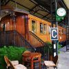 El Restaurante El Vagón de Beni en Madrid ofrece una experiencia gastronómica única en un antiguo vagón de tren transformado en cafetería. Disfrute de sus comidas rodeado de mesas, sillas, exuberante vegetación y un reloj en el techo en este encantador entorno que evoca el ambiente de un restaurante tradicional. - ForTwo - Planes para parejas