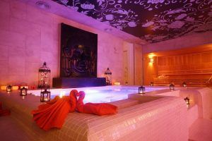 The Secret Experience Urban Spa 1850 Barcelona ofrece una lujosa sala de spa urbano con bañera de hidromasaje iluminada, obras de arte de Buda, linternas y toallas naranjas dobladas en forma de cisnes en el corazón de la ciudad. - ForTwo - Planes para parejas