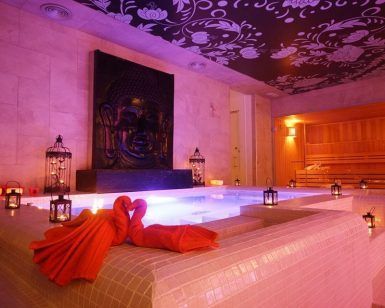 The Secret Experience Urban Spa 1850 Barcelona ofrece una lujosa sala de spa urbano con bañera de hidromasaje iluminada, obras de arte de Buda, linternas y toallas naranjas dobladas en forma de cisnes en el corazón de la ciudad. - ForTwo - Planes para parejas
