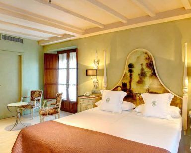 Disfrute de una elegante habitación ideal para una escapada en una encantadora casa del siglo XVIII, con cama doble, decoración vintage, iluminación tenue y vigas de madera. Disfrute del desayuno en la mesa redonda junto a la ventana. Nombre del producto: Escapada con desayuno y botella de cava a una casa del siglo XVIII (Sevilla). - ForTwo - Planes para parejas