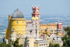 El Palacio de la Pena, parte del paquete "Visita a Sintra y Cascais con entrada para visitar el palacio de la Pena (Lisboa)", ofrece una arquitectura vibrante y ecléctica frente a las colinas y el cielo en Sintra, Portugal. - ForTwo - Planes para parejas