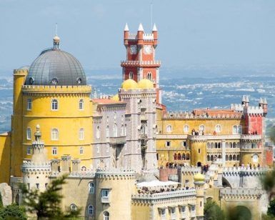 El Palacio de la Pena, parte del paquete "Visita a Sintra y Cascais con entrada para visitar el palacio de la Pena (Lisboa)", ofrece una arquitectura vibrante y ecléctica frente a las colinas y el cielo en Sintra, Portugal. - ForTwo - Planes para parejas