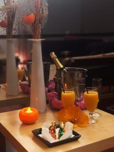 Una acogedora mesa decorada con zumo de naranja, champán, una vela y flores captura el ambiente relajante del Circuito termal de spa - Tratamiento deluxe en Tenerife. - ForTwo - Planes para parejas