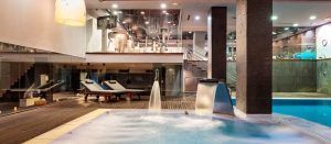 Descubra el lujo del Spa Miguel Ángel Wellness Club 5 estrellas con spa interior, equipado con jacuzzi, tumbonas y una decoración contemporánea bajo una iluminación suave. - ForTwo - Planes para parejas