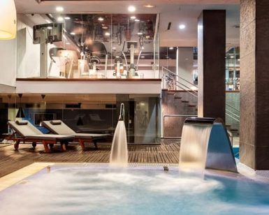 Descubra el lujo del Spa Miguel Ángel Wellness Club 5 estrellas con spa interior, equipado con jacuzzi, tumbonas y una decoración contemporánea bajo una iluminación suave. - ForTwo - Planes para parejas