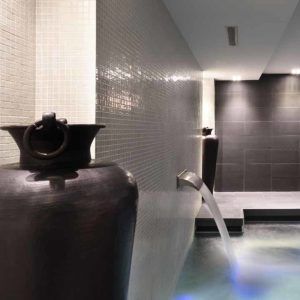 Descubra la serenidad en el Circuito Spa para 2 del Grums Hotel Spa de Barcelona. Nuestra moderna sala de spa ofrece grandes jarrones oscuros, relajantes fuentes de agua e iluminación tenue, creando una atmósfera tranquila que encapsula nuestra exclusiva experiencia de spa. - ForTwo - Planes para parejas