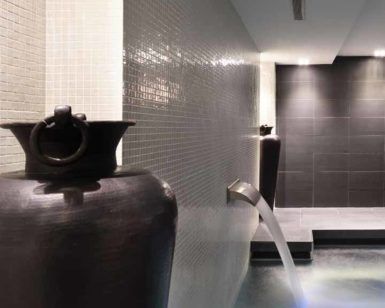 Descubra la serenidad en el Circuito Spa para 2 del Grums Hotel Spa de Barcelona. Nuestra moderna sala de spa ofrece grandes jarrones oscuros, relajantes fuentes de agua e iluminación tenue, creando una atmósfera tranquila que encapsula nuestra exclusiva experiencia de spa. - ForTwo - Planes para parejas