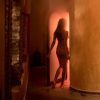 La silueta de alguien que entra en una habitación poco iluminada con una cálida luz naranja evoca el ambiente relajante de un OFERTA Hammam con masaje en Baños de Elvira (Granada). - ForTwo - Planes para parejas