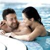 Una pareja sonríe y se abraza junto a una piscina tras disfrutar del "Spa y cena para dos en Spa Bodyna Hospes Puerta de Alcalá" en Madrid. - ForTwo - Planes para parejas