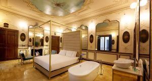 Experimente el lujo de la suite Preciosa en el Hotel Axel solo para adultos en Madrid, con su techo ornamentado, cama grande, bañera independiente y decoración elegante. - ForTwo - Planes para parejas