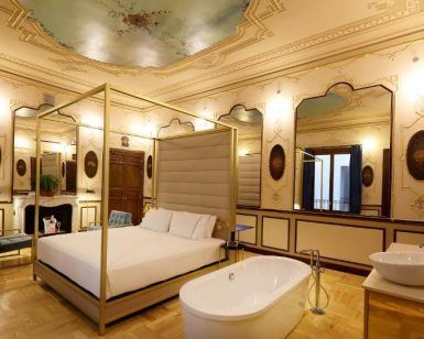 Experimente el lujo de la suite Preciosa en el Hotel Axel solo para adultos en Madrid, con su techo ornamentado, cama grande, bañera independiente y decoración elegante. - ForTwo - Planes para parejas