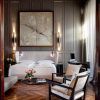Descubra la elegancia de nuestras Suites únicas en el Hotel Palacio De Villapanés (Sevilla), con cama de matrimonio, acogedores sillones, puertas decorativas de madera y un impresionante cuadro abstracto de gran tamaño. - ForTwo - Planes para parejas