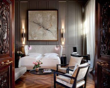 Descubra la elegancia de nuestras Suites únicas en el Hotel Palacio De Villapanés (Sevilla), con cama de matrimonio, acogedores sillones, puertas decorativas de madera y un impresionante cuadro abstracto de gran tamaño. - ForTwo - Planes para parejas