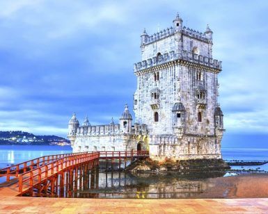 La imagen captura la Torre de Belém en Lisboa, Portugal, junto al mar bajo un cielo nublado al atardecer, mostrando una vista impresionante como las de la 'Vuelta en barco hasta Belém con tour por el barrio (Lisboa)'. - ForTwo - Planes para parejas