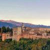 Encaramada en una colina, la fortaleza presume de majestuosas torres y murallas que contrastan con impresionantes montañas bajo un cielo despejado. Experimente la grandeza de este monumento con la "Visita privada exclusiva para parejas con entradas y guía oficial por la Alhambra". - ForTwo - Planes para parejas