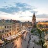 Vista aérea de una bulliciosa plaza europea al atardecer en Cracovia, que muestra edificios históricos, una torre y vibrantes cafés al aire libre: un entorno ideal para comenzar su Tour gratuito por la ciudad de Cracovia. - ForTwo - Planes para parejas