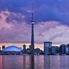 El "Tour por el este de Canadá" presenta el horizonte de Toronto al atardecer, donde la Torre CN y las nubes de colores se reflejan de forma impresionante en las tranquilas aguas. - ForTwo - Planes para parejas