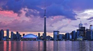 El "Tour por el este de Canadá" presenta el horizonte de Toronto al atardecer, donde la Torre CN y las nubes de colores se reflejan de forma impresionante en las tranquilas aguas. - ForTwo - Planes para parejas