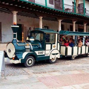 Un pequeño tren turístico lleno de gente se desliza entre la arquitectura histórica adornada con columnas, ofreciendo un vistazo a la rica historia de la zona en la Visita guiada a Bodega del Nero con tren turístico y degustación de 3 vinos. - ForTwo - Planes para parejas