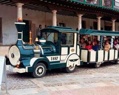 Un pequeño tren turístico lleno de gente se desliza entre la arquitectura histórica adornada con columnas, ofreciendo un vistazo a la rica historia de la zona en la Visita guiada a Bodega del Nero con tren turístico y degustación de 3 vinos. - ForTwo - Planes para parejas