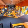 En Urban Planet Jump Las Rejas, Madrid, los visitantes saltan enérgicamente en coloridos trampolines naranjas y negros en el bullicioso parque interior. - ForTwo - Planes para parejas
