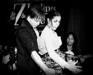 En los encantadores Jardines de Zoraya, un hombre y una mujer interpretan apasionadamente un baile flamenco en el escenario mientras un guitarrista toca cerca, creando un espectáculo de flamenco en los Jardines de Zoraya inolvidable. - ForTwo - Planes para parejas