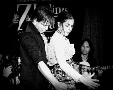 En los encantadores Jardines de Zoraya, un hombre y una mujer interpretan apasionadamente un baile flamenco en el escenario mientras un guitarrista toca cerca, creando un espectáculo de flamenco en los Jardines de Zoraya inolvidable. - ForTwo - Planes para parejas