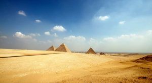 Embárcate en el "Viaje a Egipto de 8 días" de 8 días a través del desierto, donde se alzan las majestuosas Pirámides de Giza bajo un cielo azul con nubes dispersas. - ForTwo - Planes para parejas