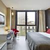 Alójese en el Hotel Vincci Gala de Barcelona, donde le espera una habitación moderna con una cama grande, una elegante decoración en rojo y gris, un televisor, un escritorio y una ventana con impresionantes vistas a la ciudad. - ForTwo - Planes para parejas