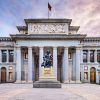 Vista frontal del Museo del Prado en Madrid, con una estatua de Velázquez al atardecer. Complemente su visita con una "Visita guiada por el Museo del Prado". - ForTwo - Planes para parejas