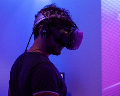 Un usuario se pone los auriculares Realidad Virtual en Pareja en Oasis VR Experience en San Sebastián de los Reyes, Madrid, y entra en un vibrante mundo virtual inundado de tonos morados y azules. - ForTwo - Planes para parejas