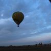 La "Oferta: vuelo en globo con hotel en Segovia" te permite sobrevolar un paisaje rural cerca de Segovia bajo un cielo nublado al atardecer, proporcionándote vistas encantadoras y momentos inolvidables. - ForTwo - Planes para parejas
