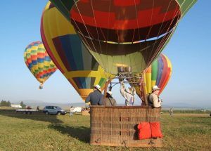 En Antequera, los participantes en una cesta de globo aerostático se preparan para el despegue con Volar en globo en Antequera, mientras varios globos de colores flotan en el fondo. - ForTwo - Planes para parejas