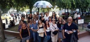 Un grupo alegre se encuentra bajo los árboles y los coches aparcados, sosteniendo con orgullo su paraguas del Free Tour. ¡Es un día perfecto para Freetour en Budapest con White Umbrella Tours en la hermosa Budapest!. - ForTwo - Planes para parejas