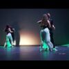 Las parejas de baile se balanceaban al ritmo de "Clases de Salsa en Sevilla: Descubre el Ritmo Latino", sus elegantes movimientos resaltados por los reflejos verdes en un escenario tenuemente iluminado. - ForTwo - Planes para parejas