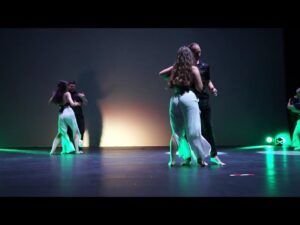 Las parejas de baile se balanceaban al ritmo de "Clases de Salsa en Sevilla: Descubre el Ritmo Latino", sus elegantes movimientos resaltados por los reflejos verdes en un escenario tenuemente iluminado. - ForTwo - Planes para parejas